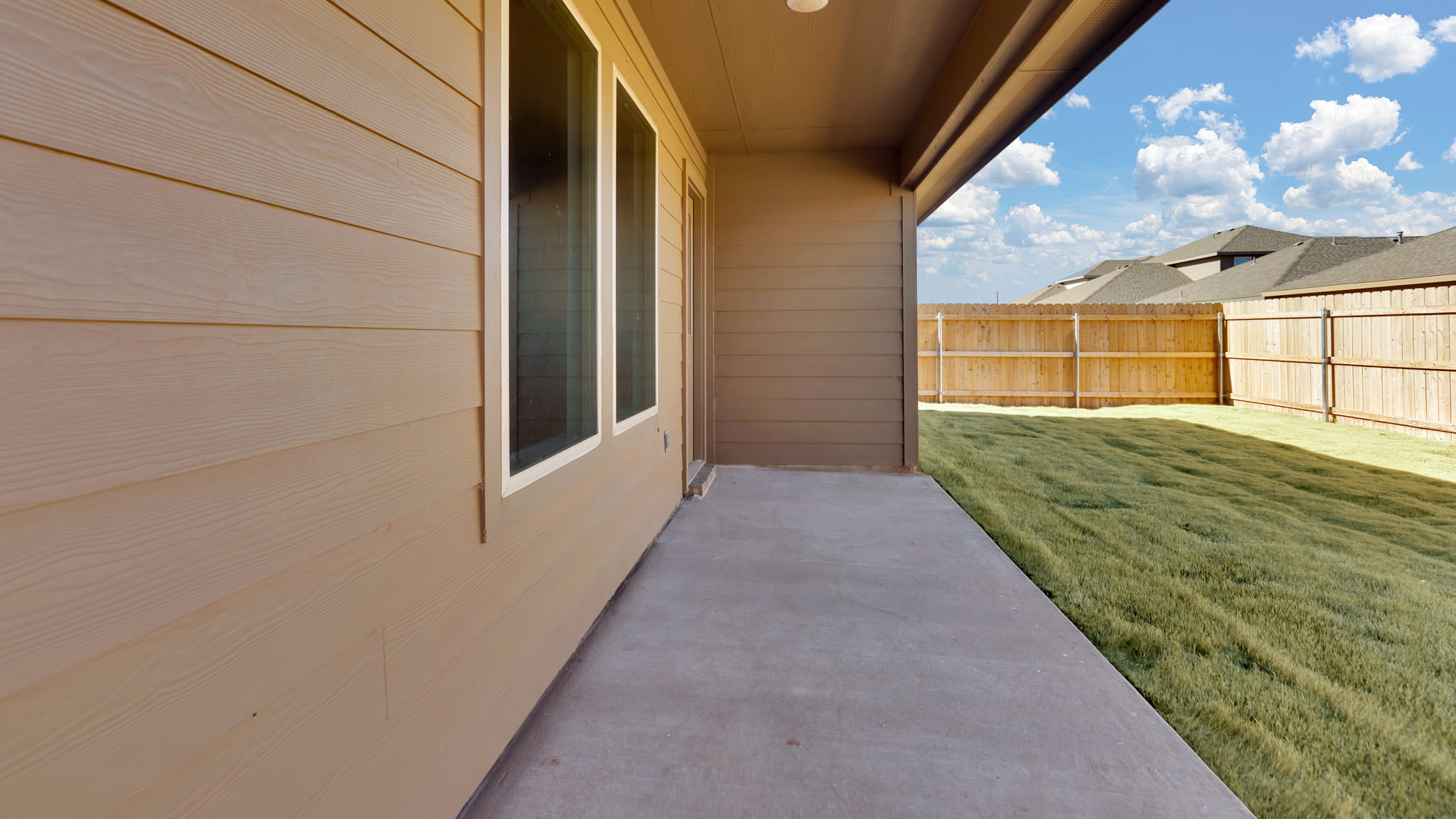 Covered patio area overlooking into spacious backyard