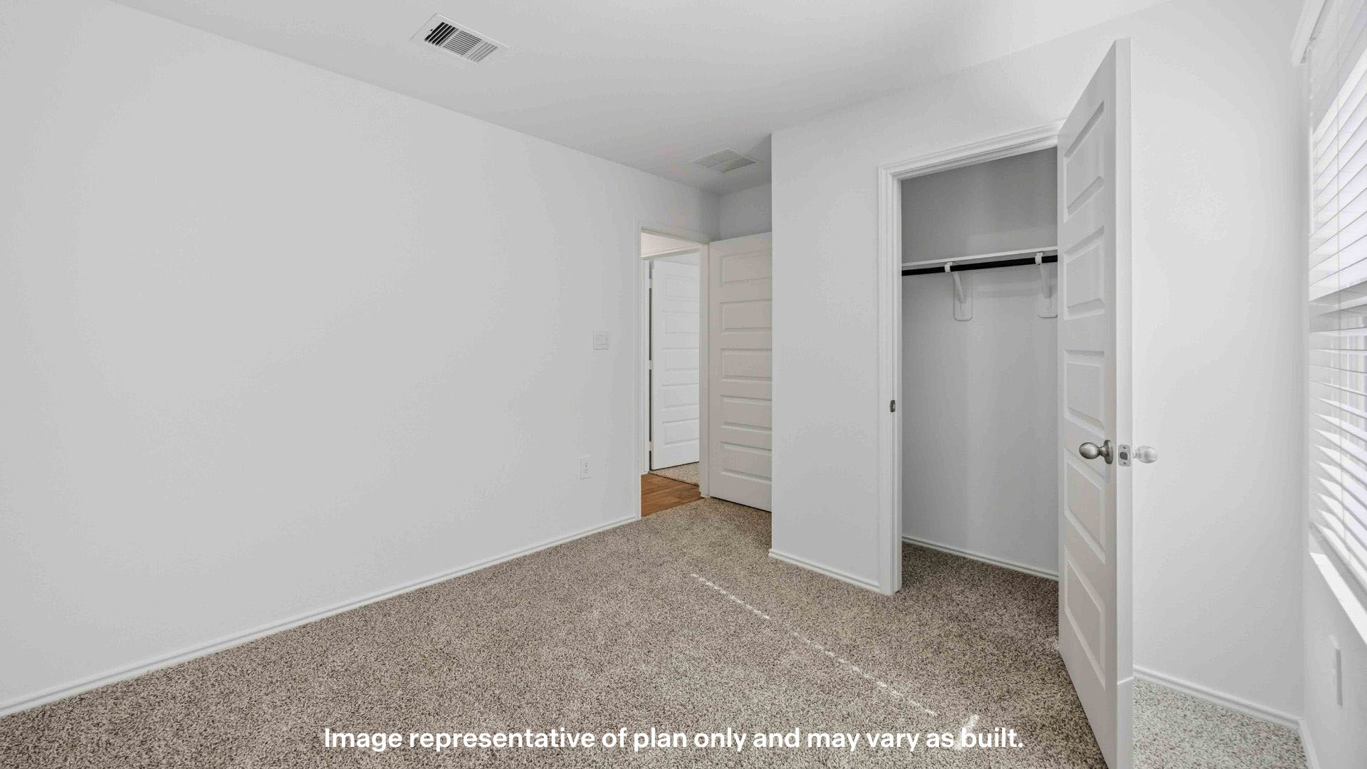 Guest bedroom with spacious closet and plush carpet floors