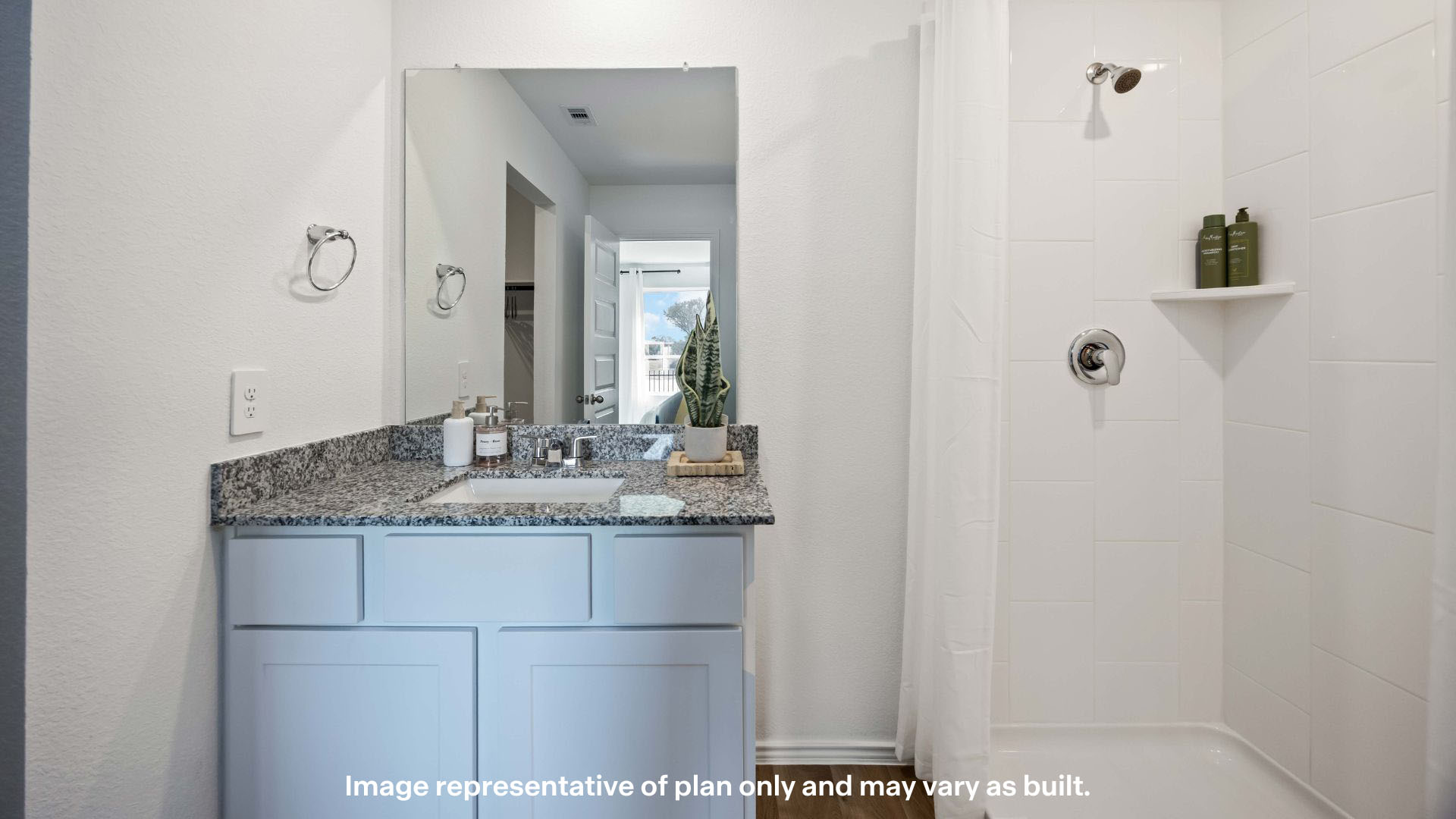 Private attached primary bathroom with built in vanity and luxurious shower