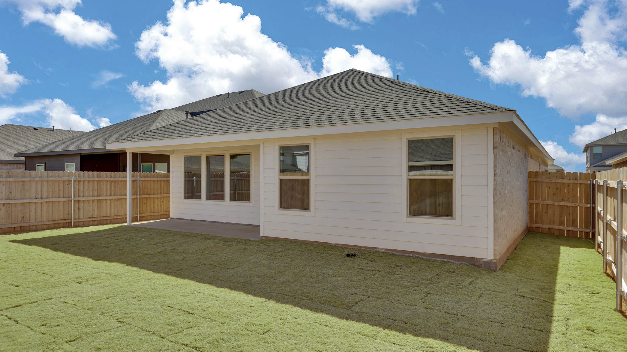 Covered back patio area overlooking spacious backyard