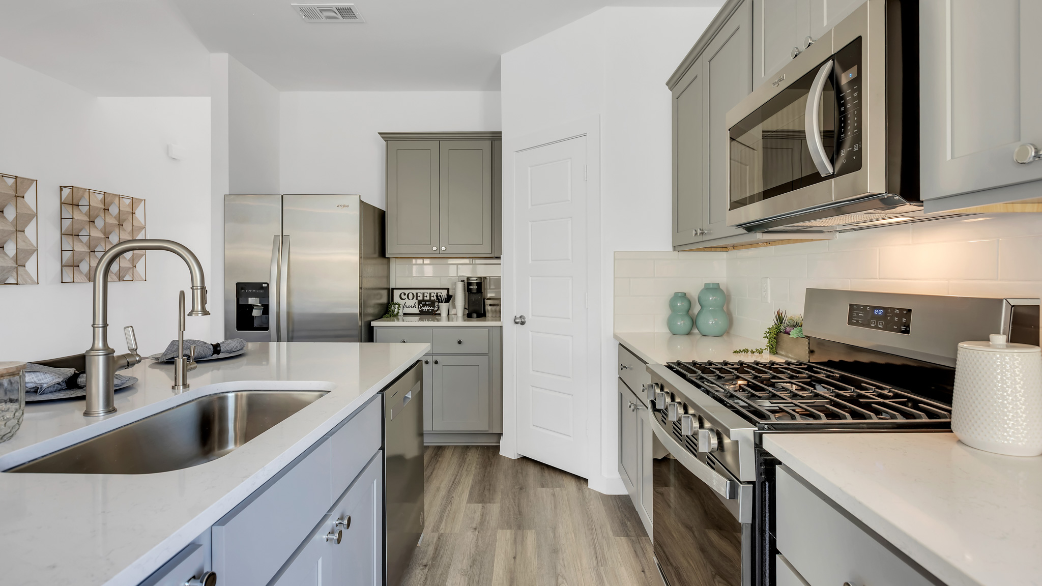Open concept kitchen with stainless steel appliances, shaker style cabinets, and elevated finishes