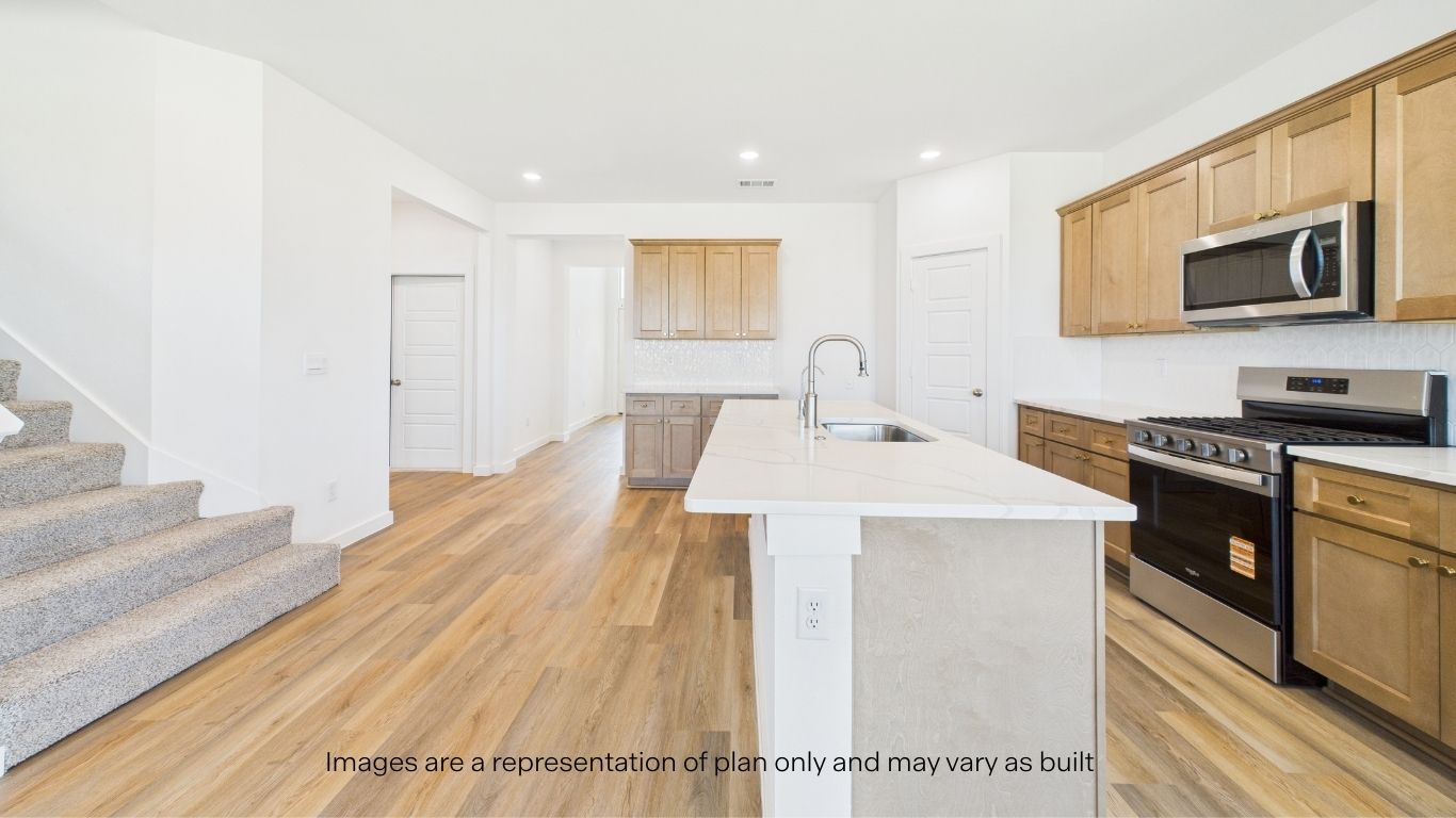 Specious open concept kitchen overlooking living area and staircase