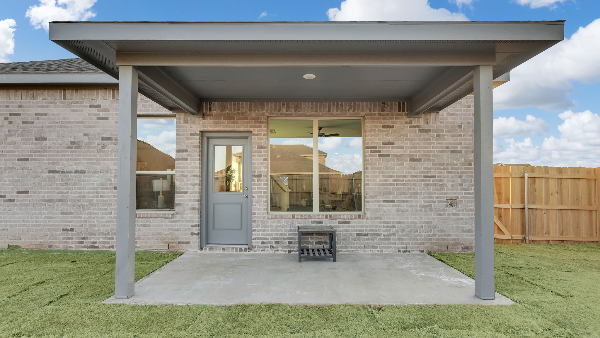 Covered back patio area overlooking spacious backyard