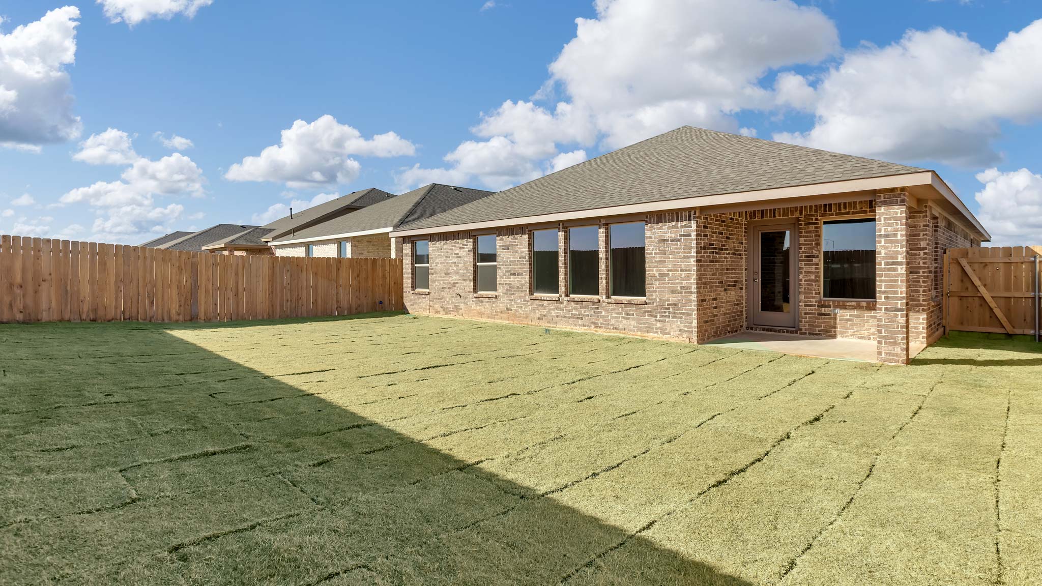 Covered back patio area overlooking spacious backyard
