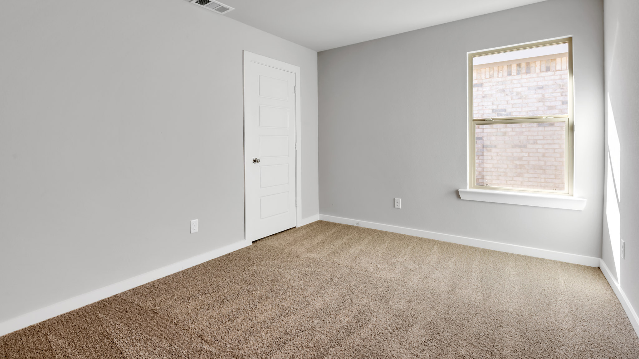 Guest bedroom with side window and plush carpet floor