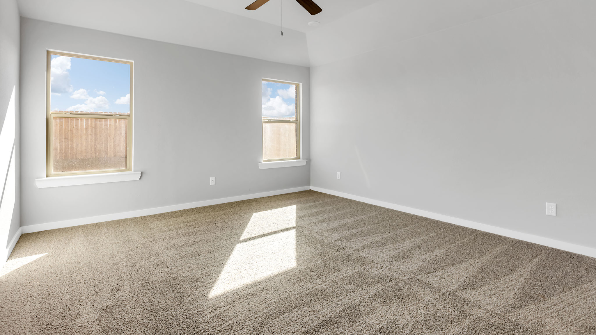 Primary bedroom with plush carpet floors and light allowing double windows