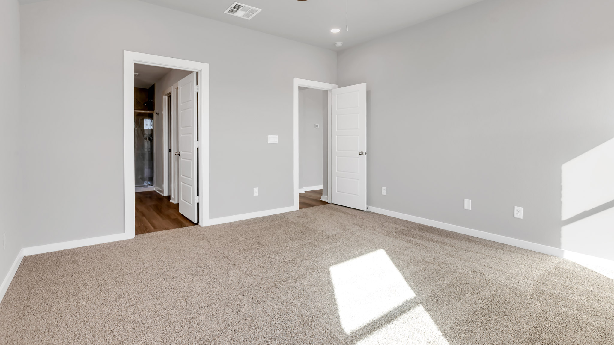 Primary bedroom with private attached bathroom and walk-in closet