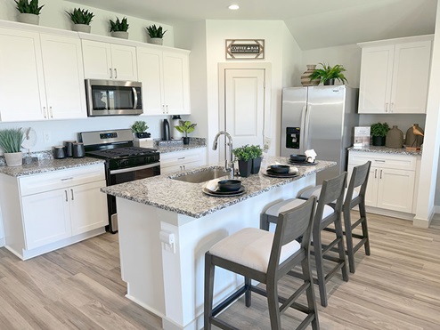 Open kitchen with granite counters, stainless steel appliances, and spacious island