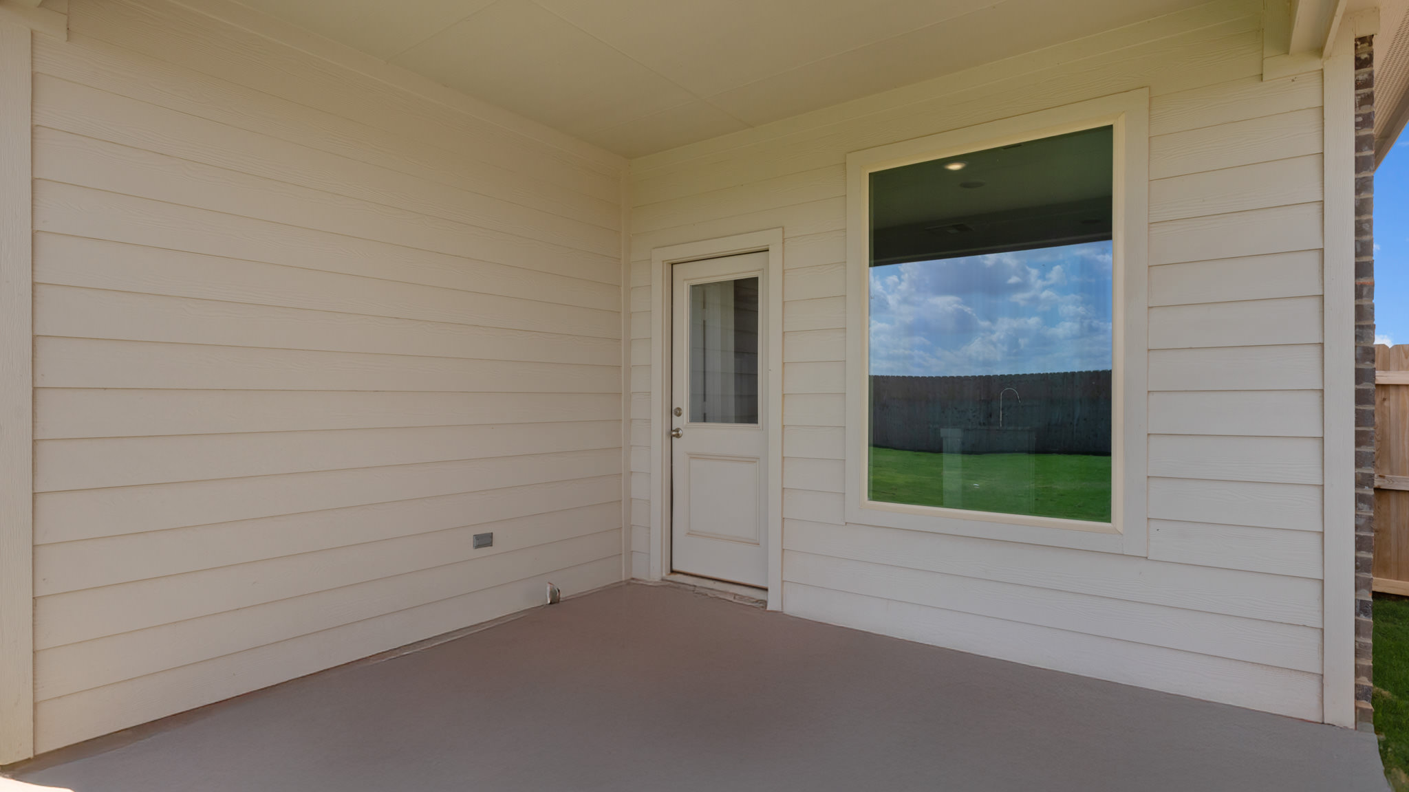Covered back patio area overlooking spacious backyard