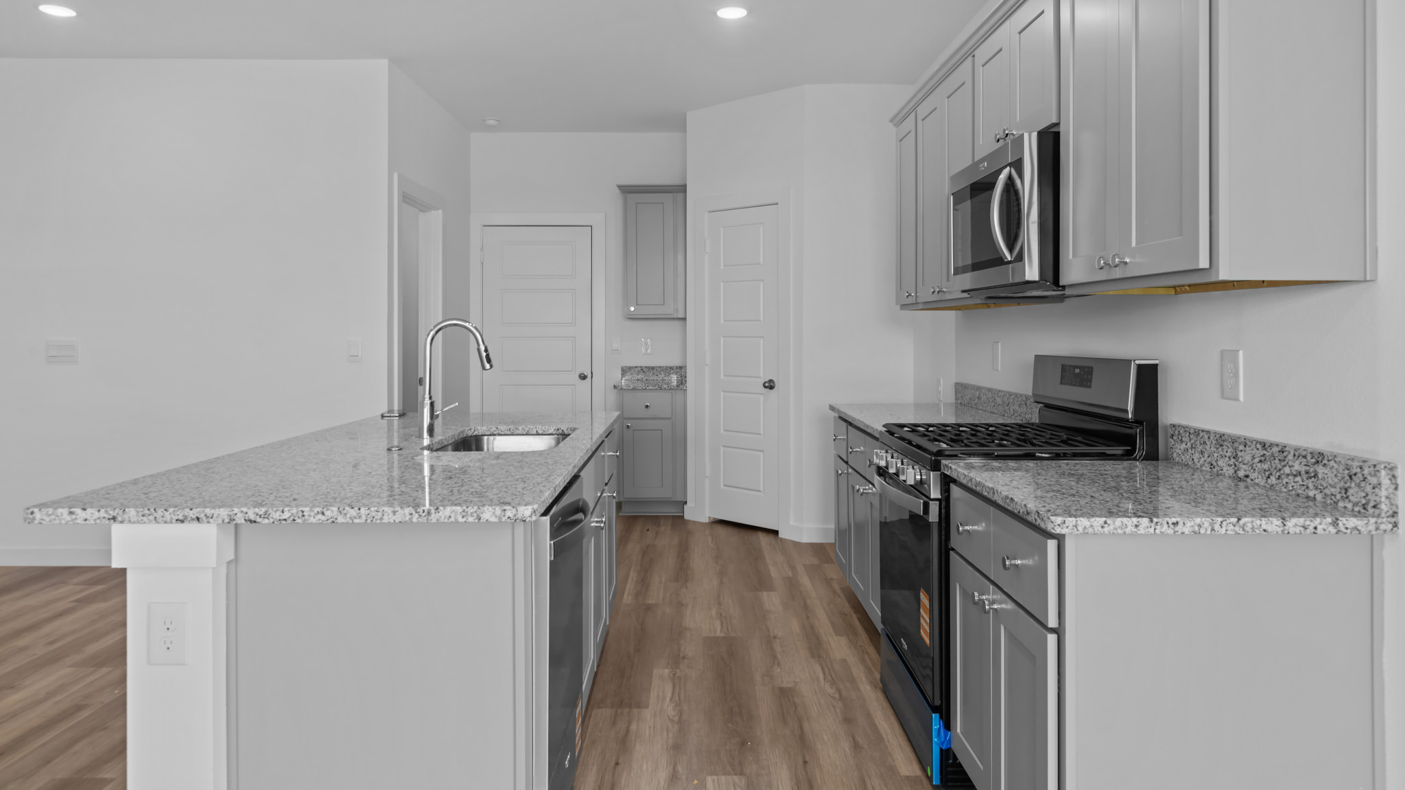 Open concept kitchen with stainless steel appliances, shaker style cabinets, and elevated finishes