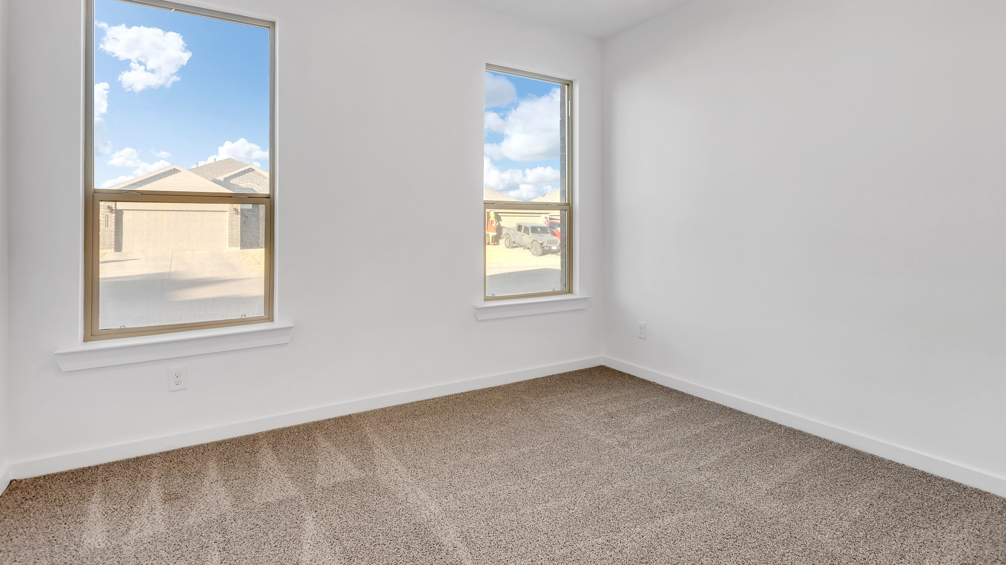 Bedroom 1 with front windows and plush carpet floors