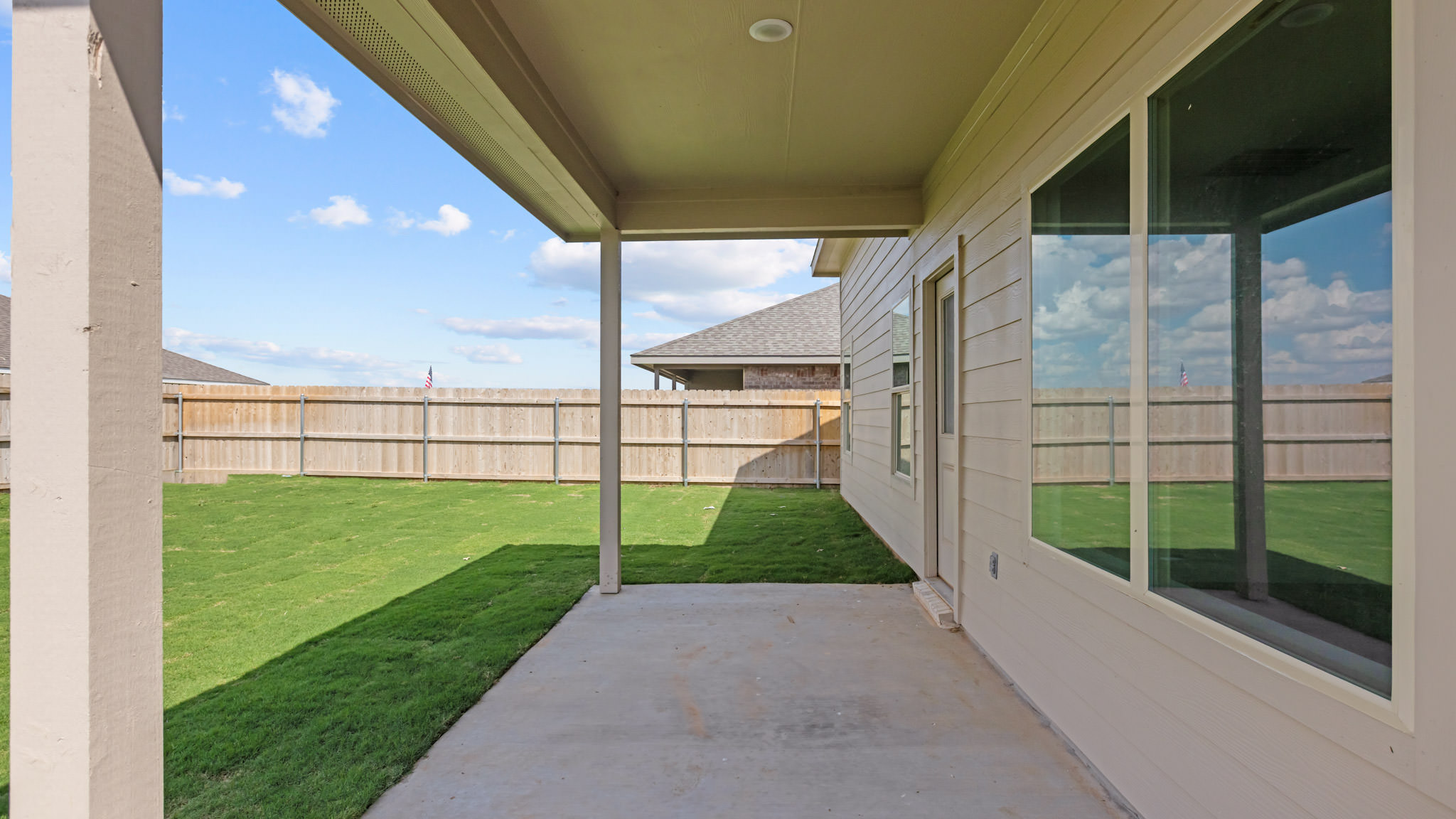 Covered back patio area overlooking private fenced-in backyard