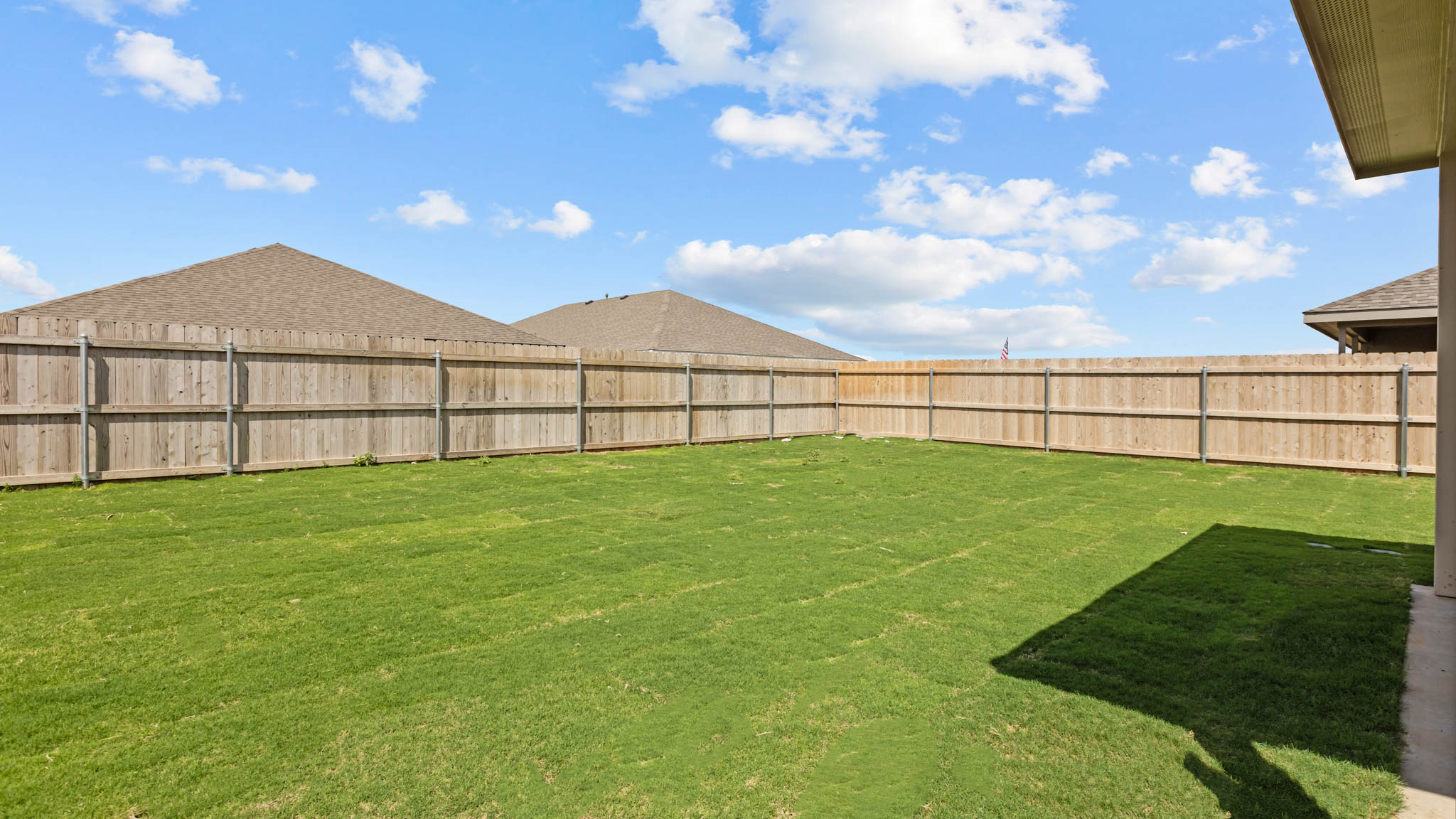 Large green backyard with private fence and covered patio