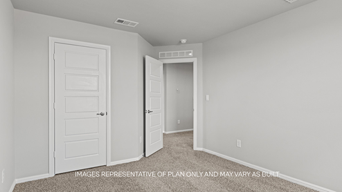 guest bedroom with plush carpet and spacious closet