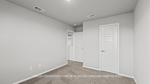 guest bedroom with plush carpet and spacious closet