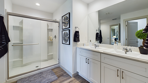 Primary bathroom with double sink, vanity and walk in shower
