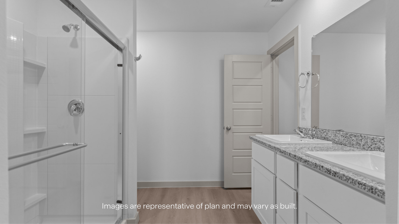 Private attached primary bathroom with built in vanity and luxurious shower.