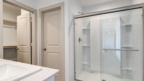 Bathroom with large shower with sliding glass doors