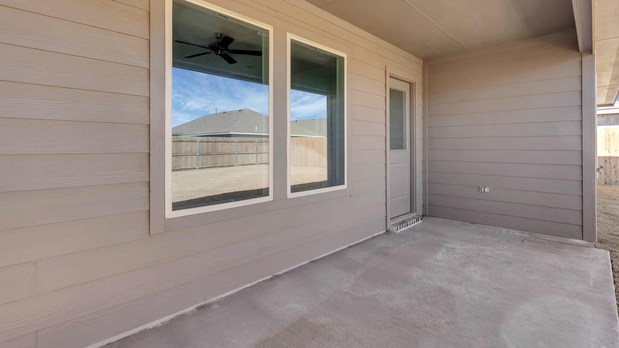 Covered back patio area overlooking spacious backyard