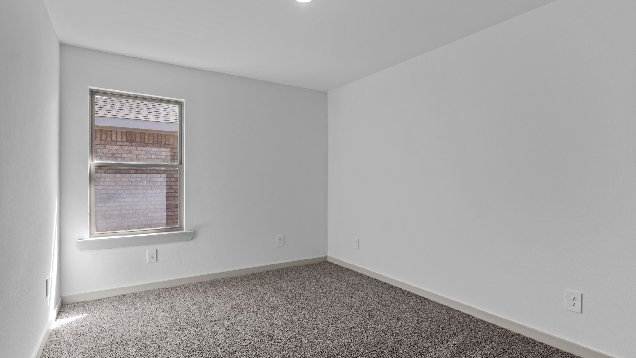 Guest bedroom with single window and plush carpet