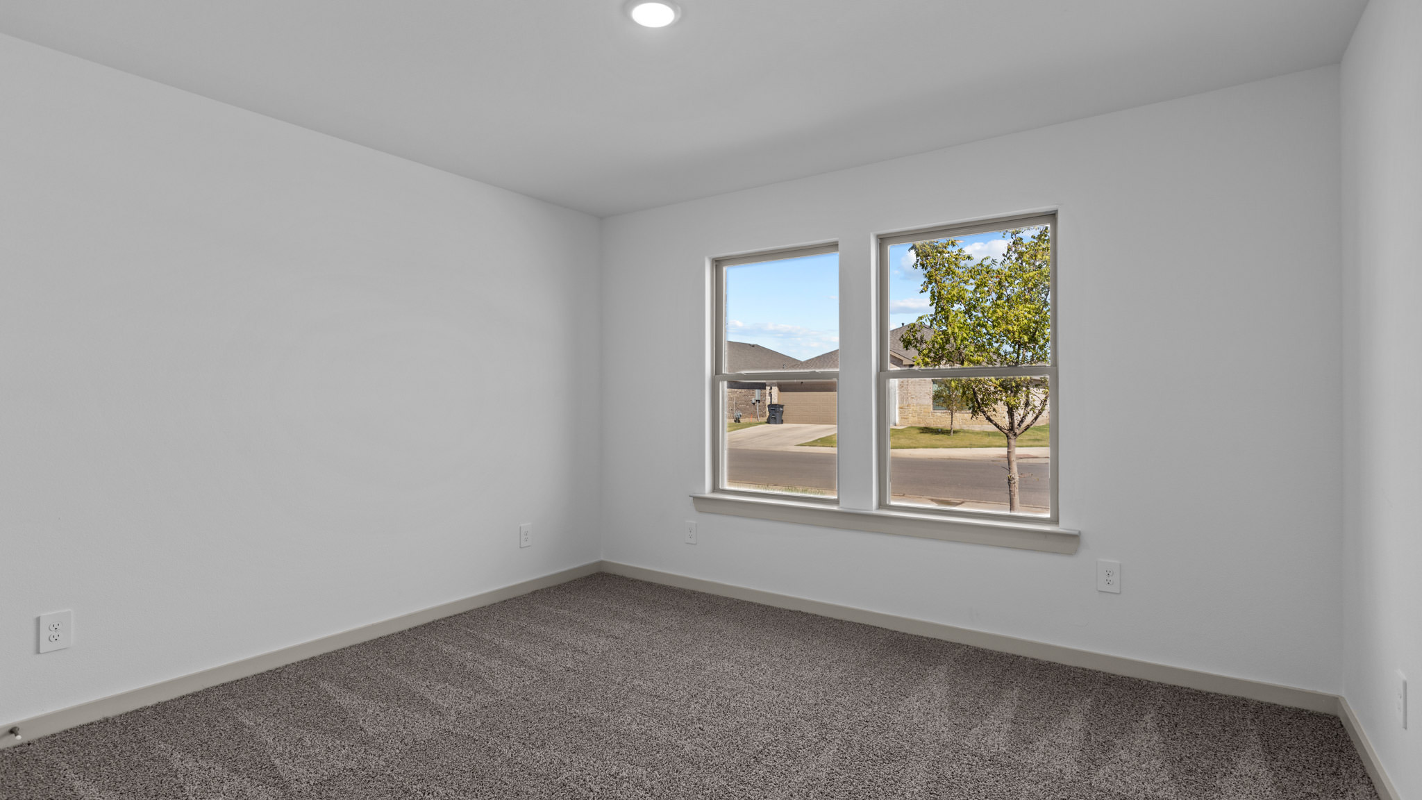Secondary bedroom with plush carpet and 2 windows