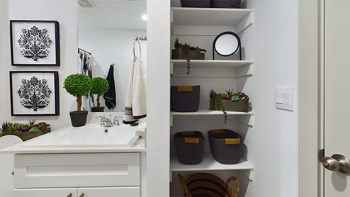 Guest bathroom with white interior and wooden shelving