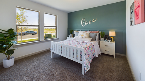 Guest bedroom with plush carpet and double window
