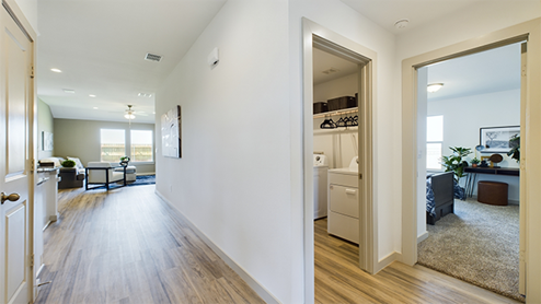 Entry hall facing family area , white interior and vinyl plank flooring