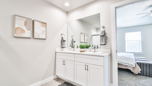 Primary bathroom with vanity with white cabinets