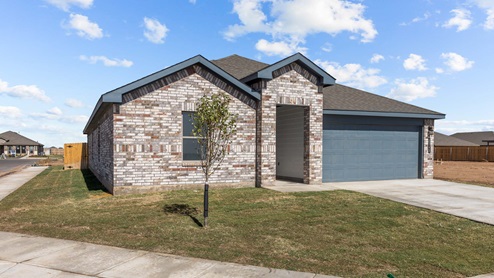 Single story home with brick, covered patio with 2 car garage