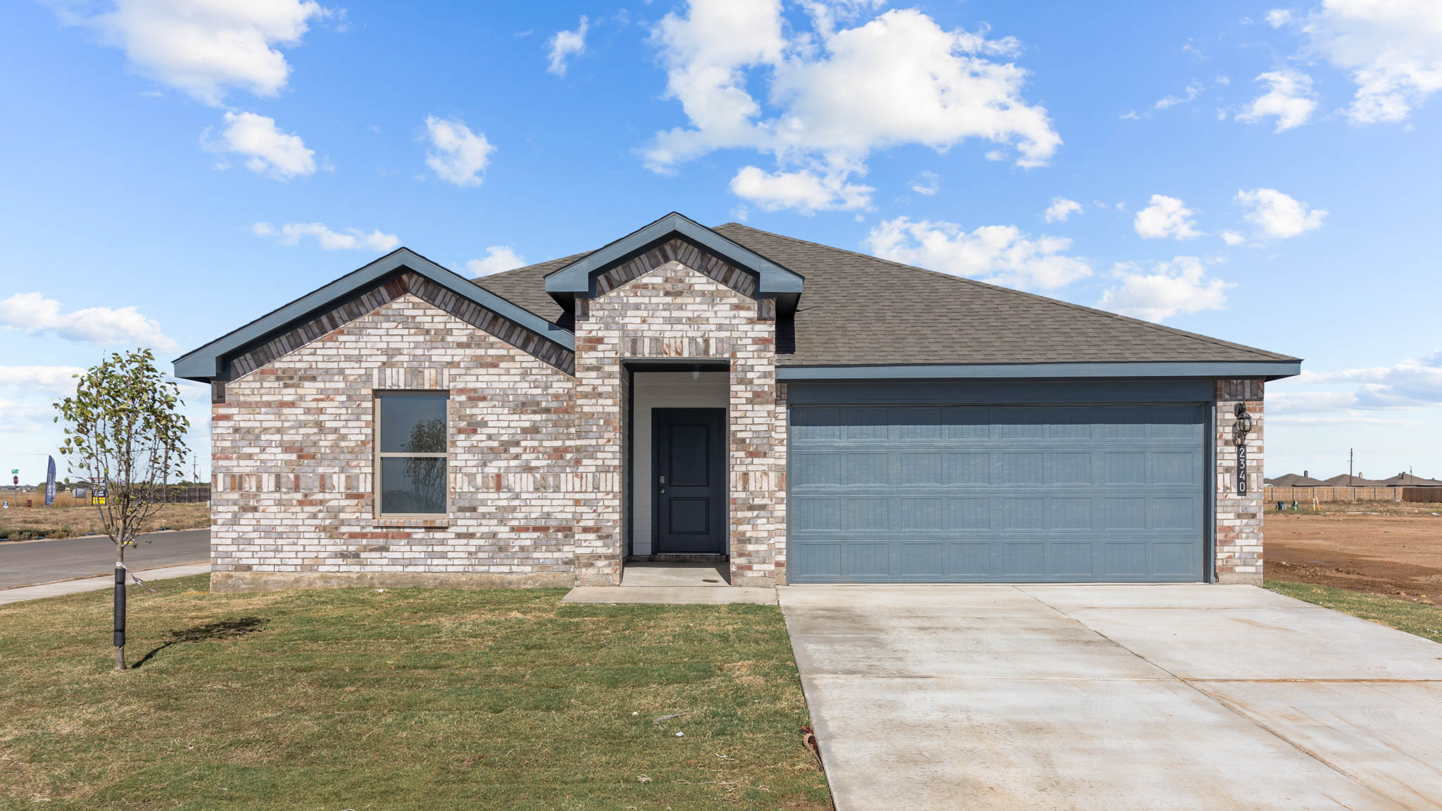 Single story home with brick, covered patio and two car garage