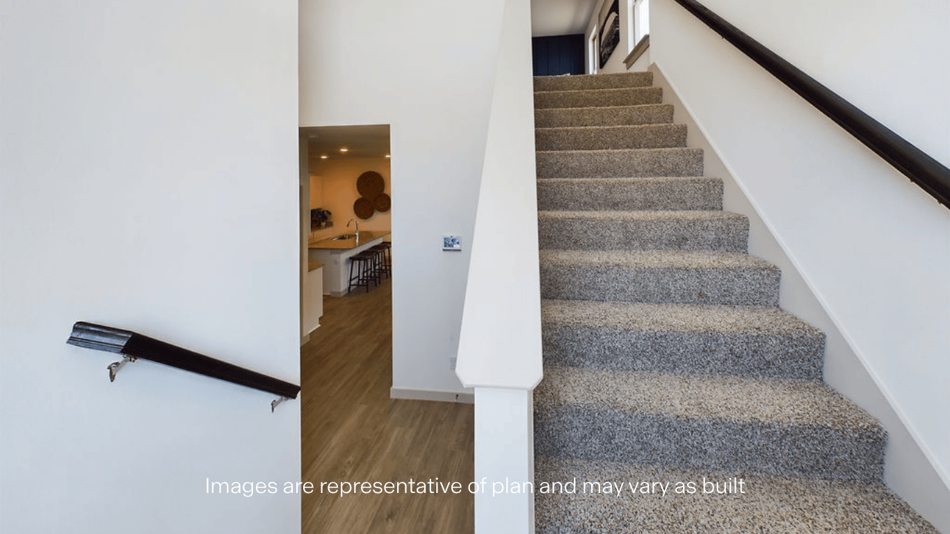 Carpeted staircase with wood tone handrails