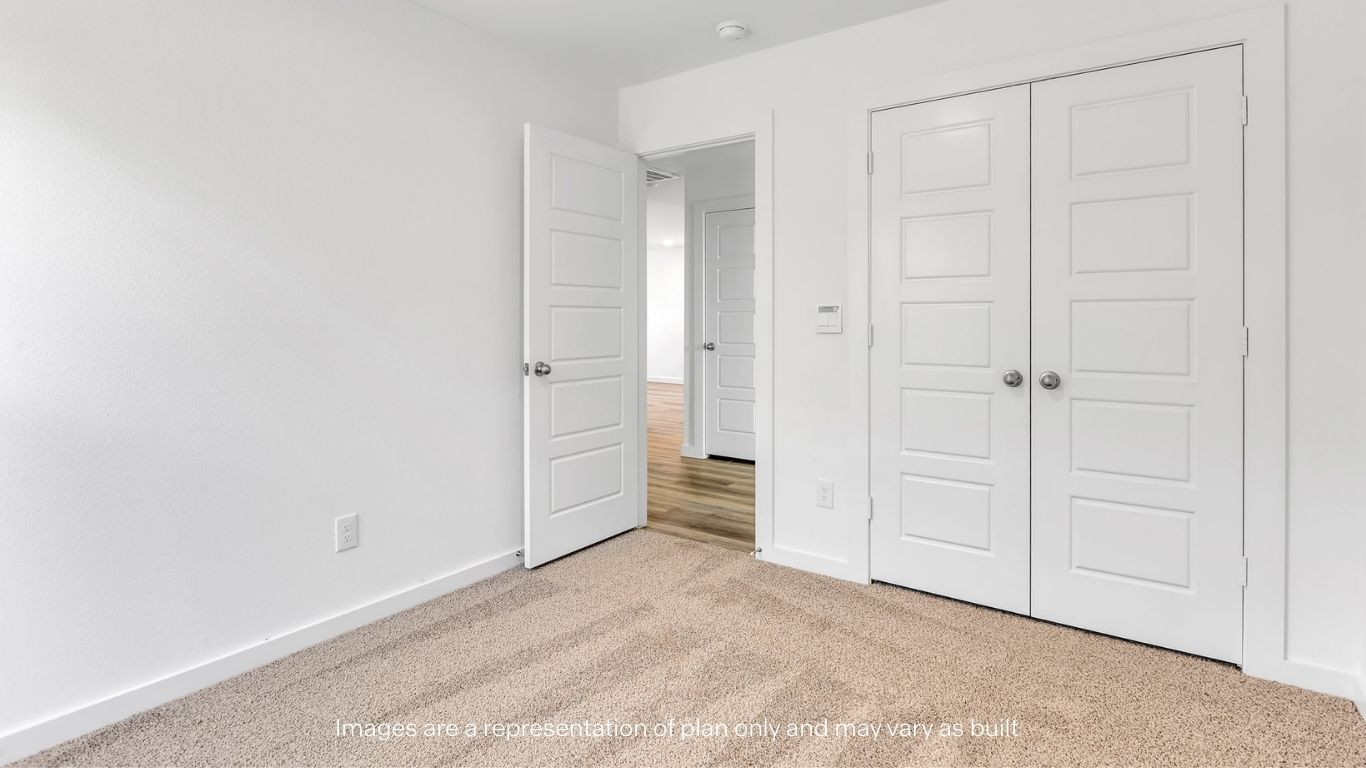 Guest bedroom with plush carpet floors and spacious closet