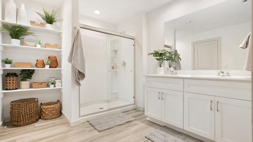 Large bathroom with white cabinets and shower