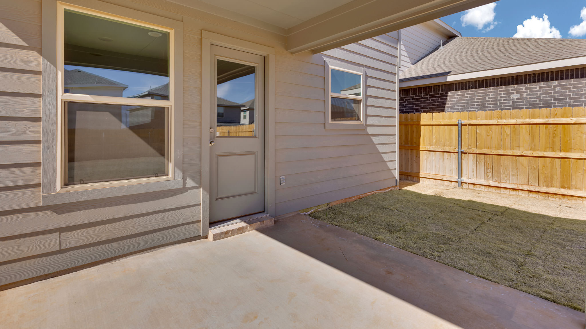 Covered back patio area overlooking spacious backyard