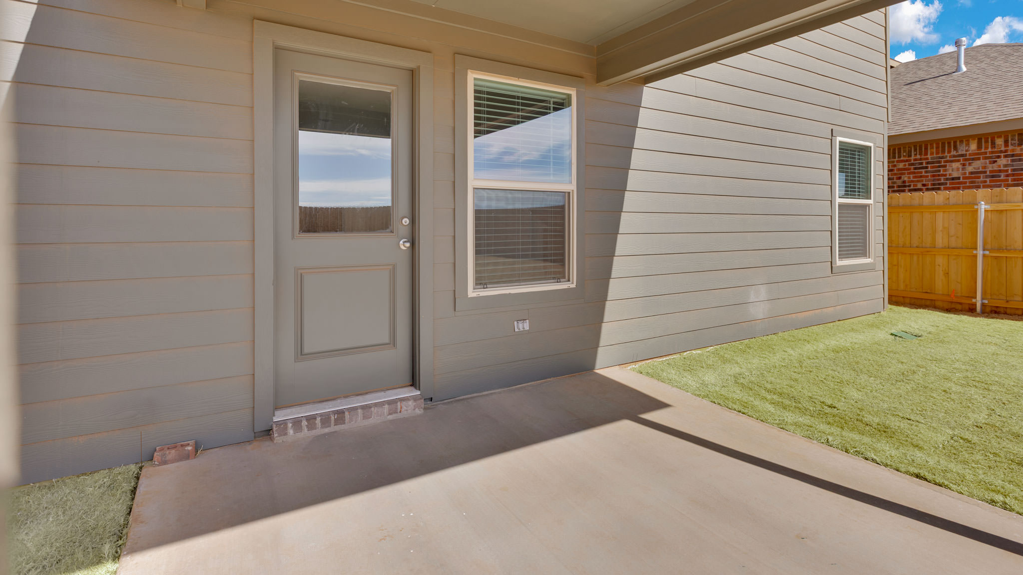Covered back patio area overlooking spacious backyard