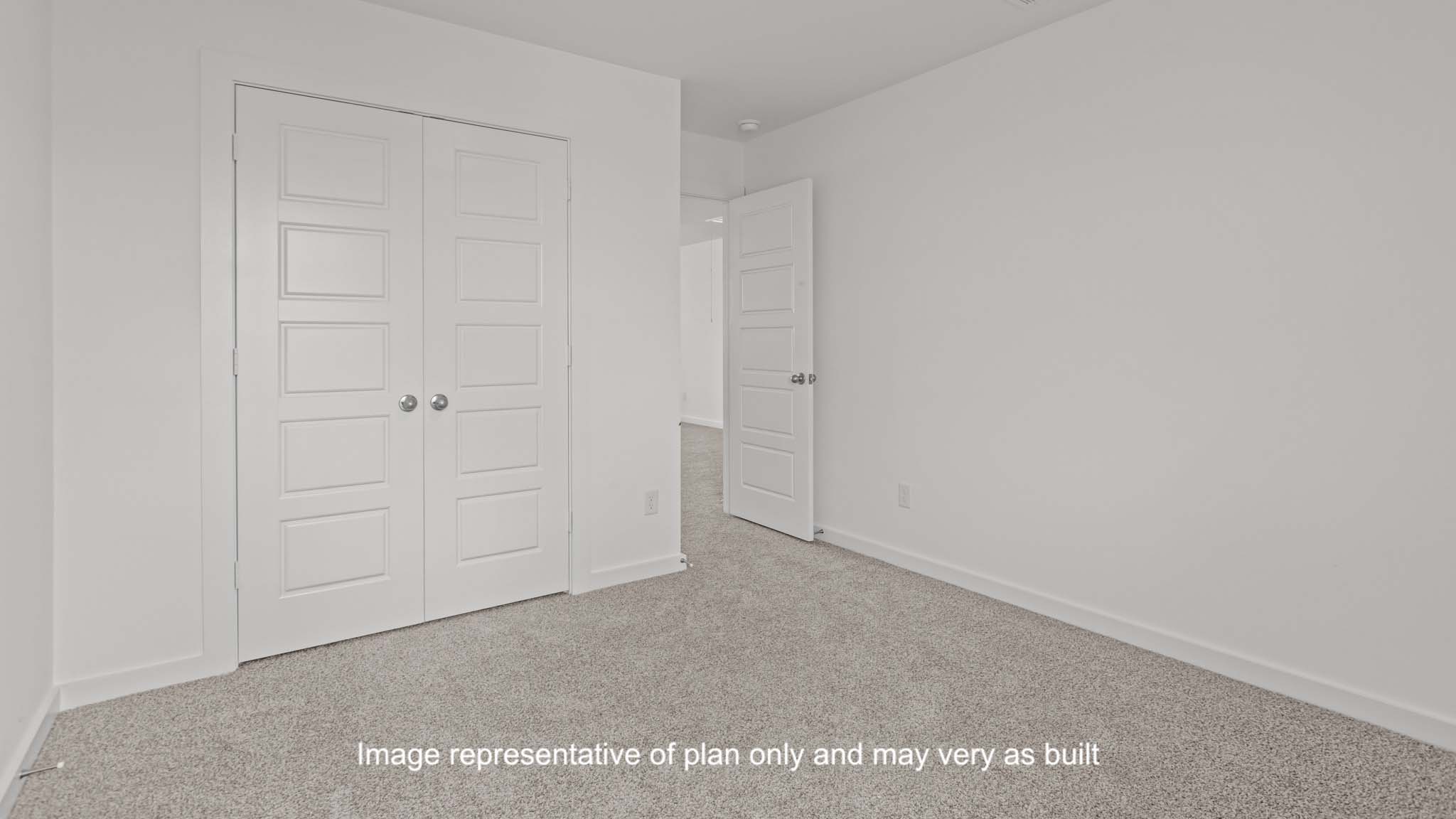 Guest bedroom with plush carpet floors and spacious closet