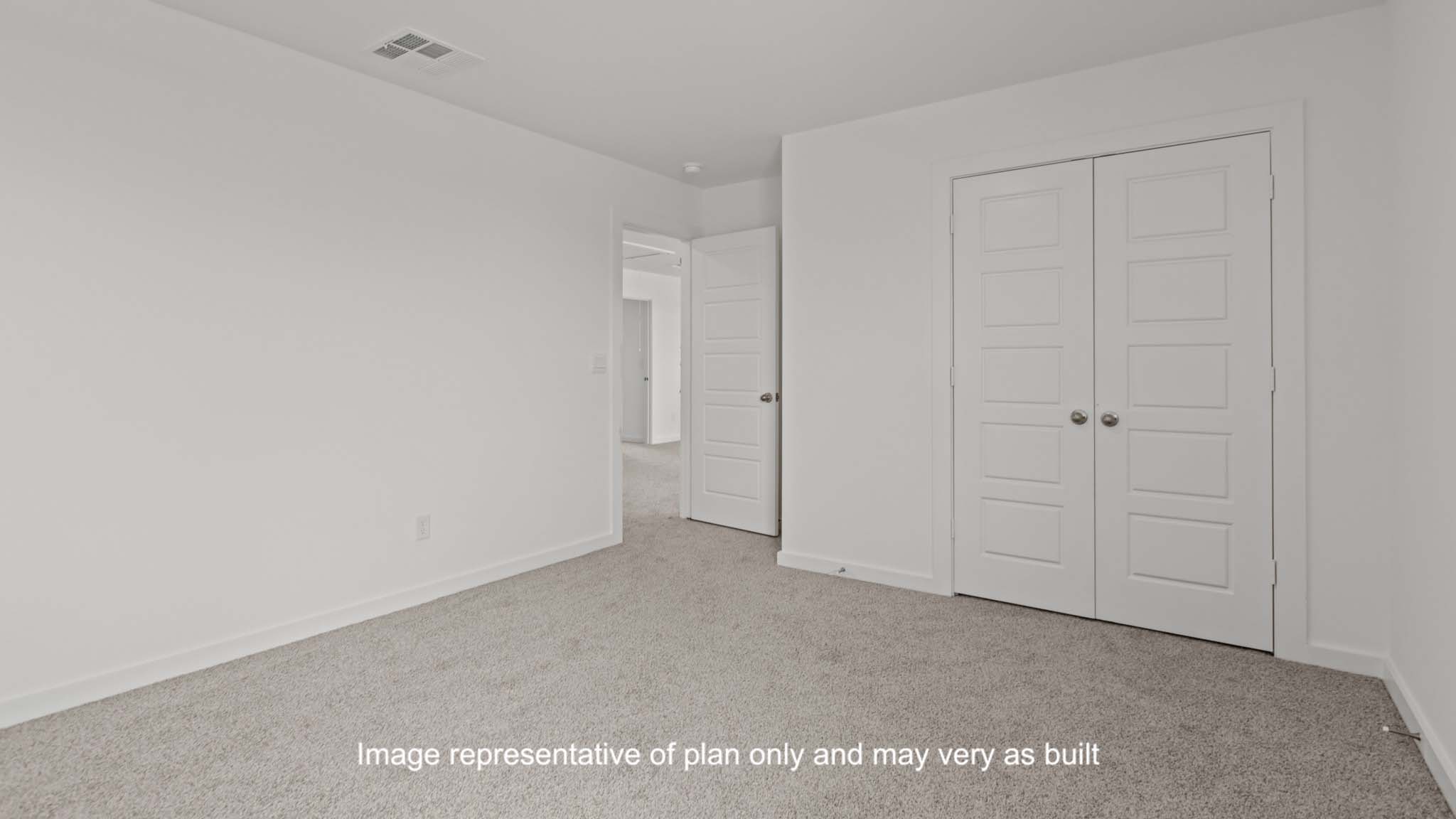 Guest bedroom with plush carpet floors and spacious closet
