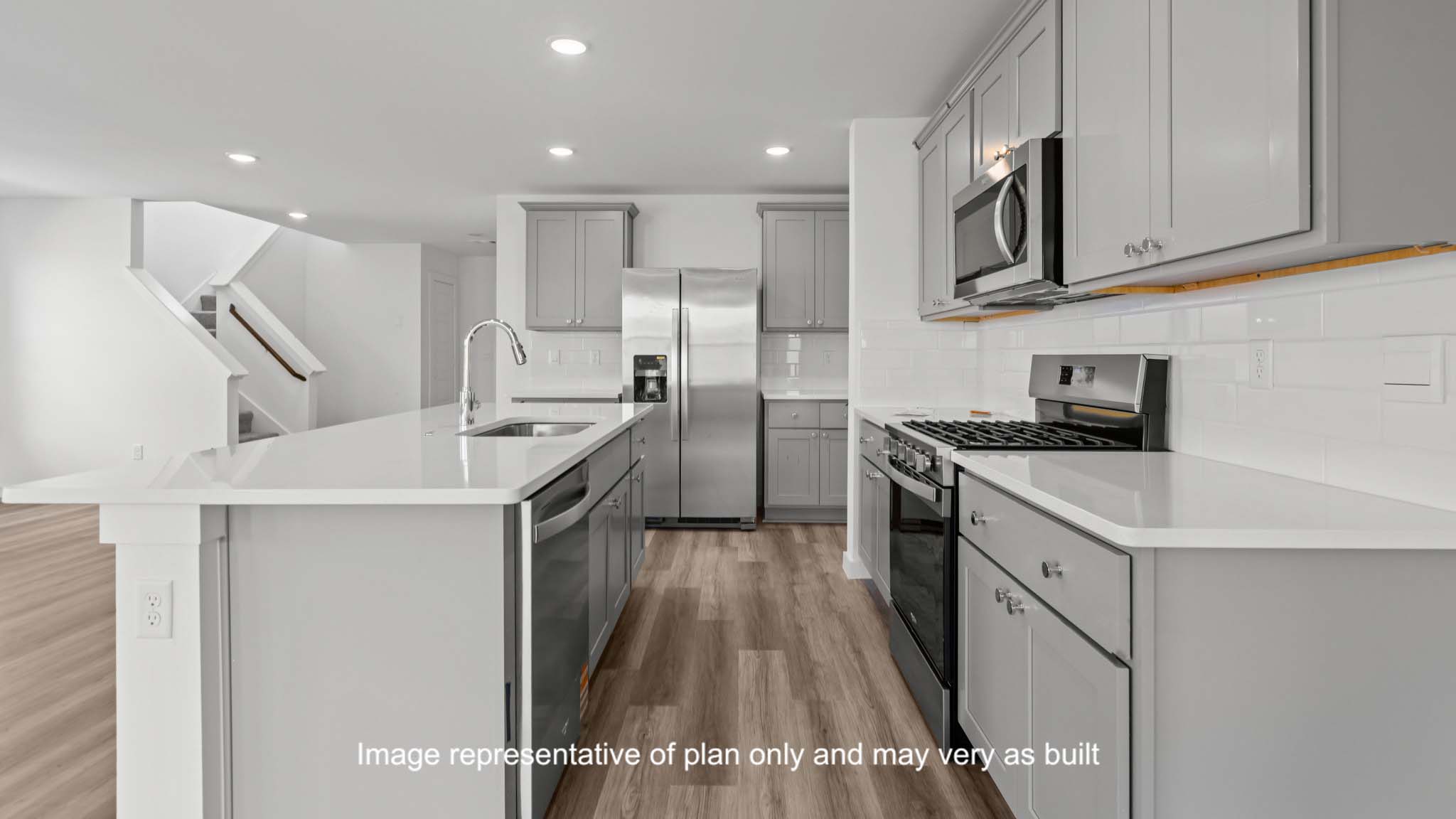 Open concept kitchen with stainless steel appliances, shaker style cabinets, and elevated finishes
