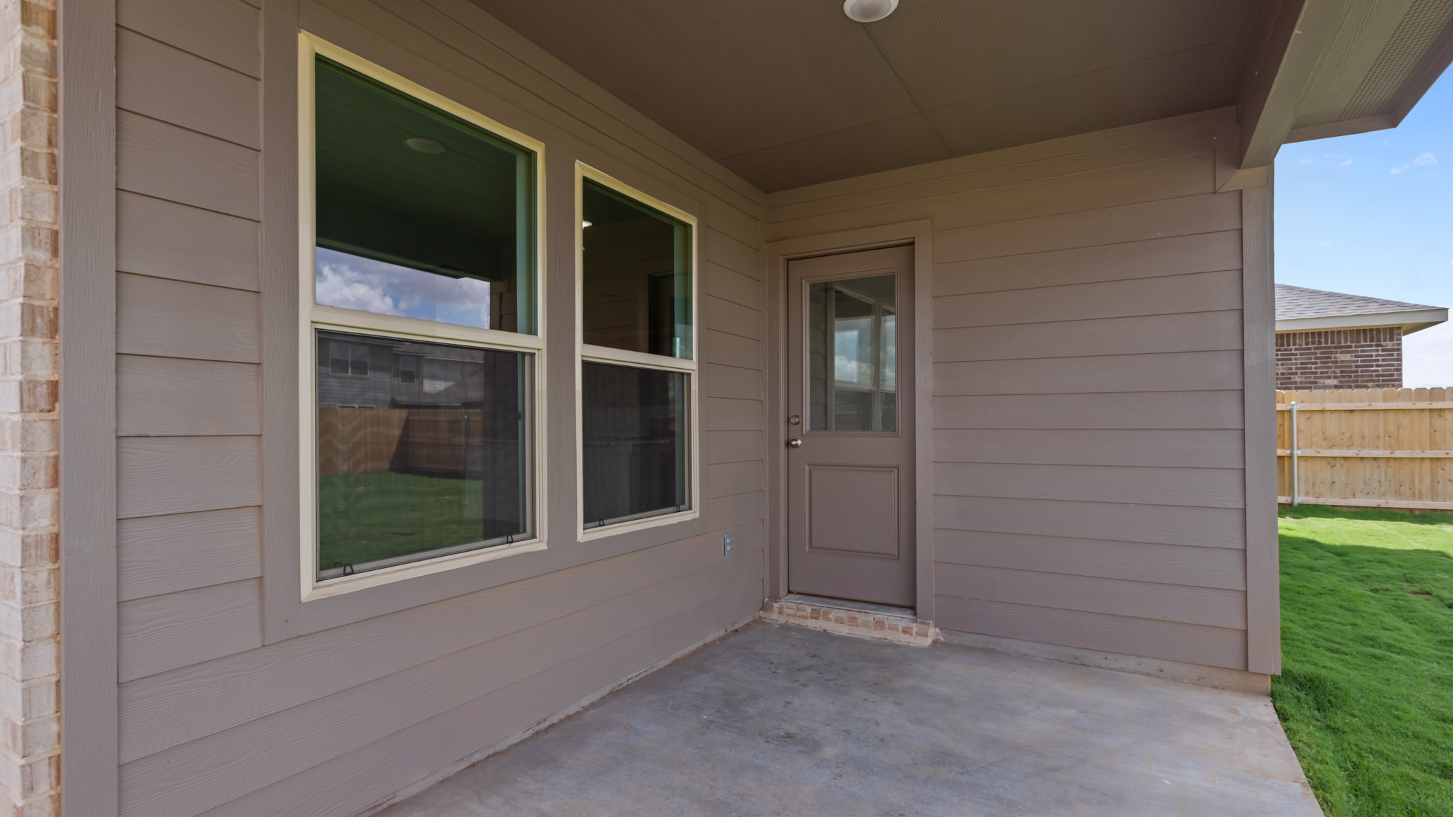Covered back patio area overlooking private fenced-in backyard