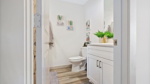 Secondary bathroom with white cabinets