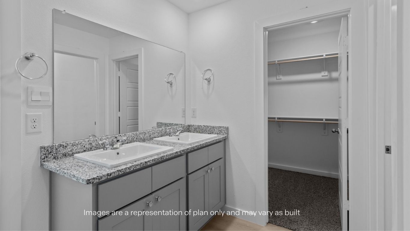 Private attached primary bathroom with built in vanity and walk in closet