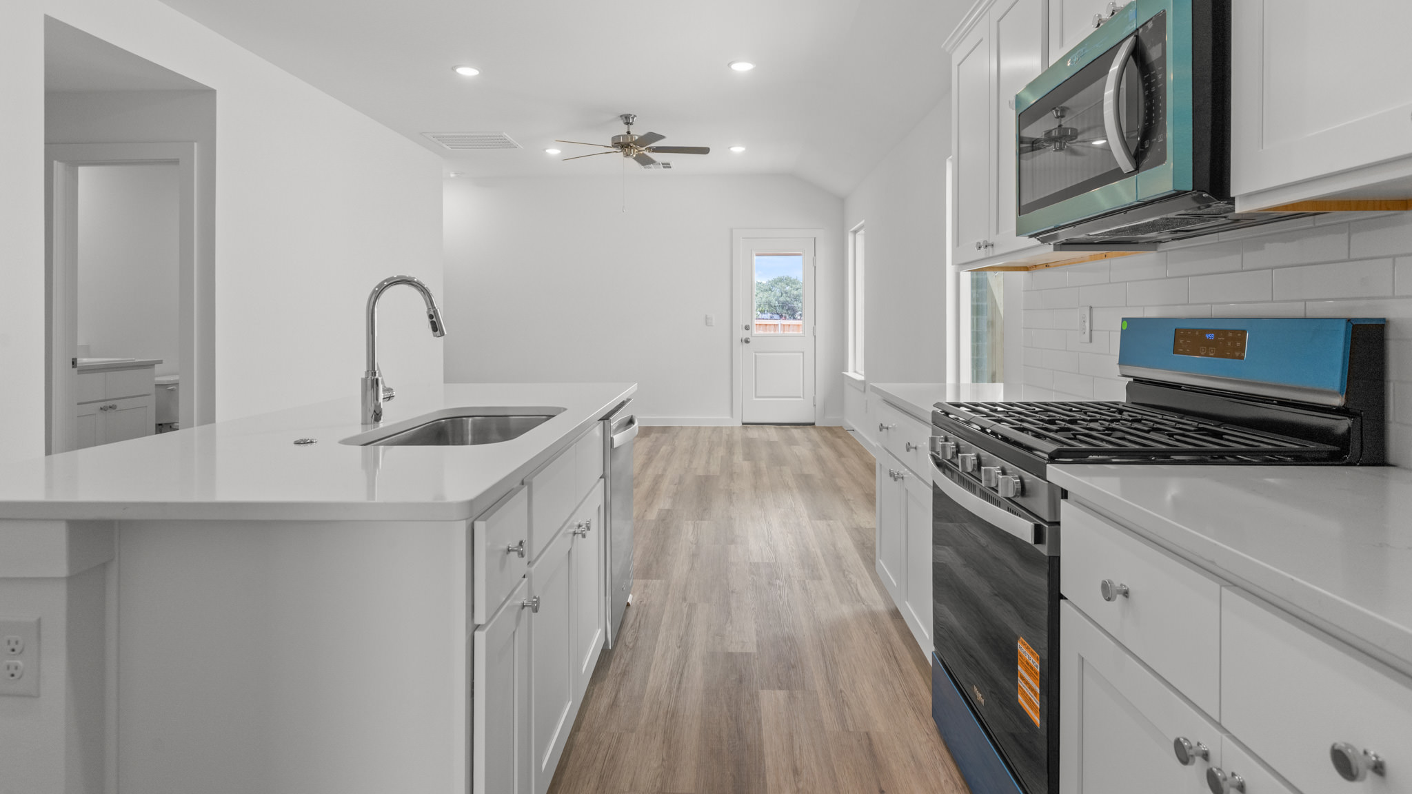 kitchen with spacious island, quartz counters and stainless-steel appliances