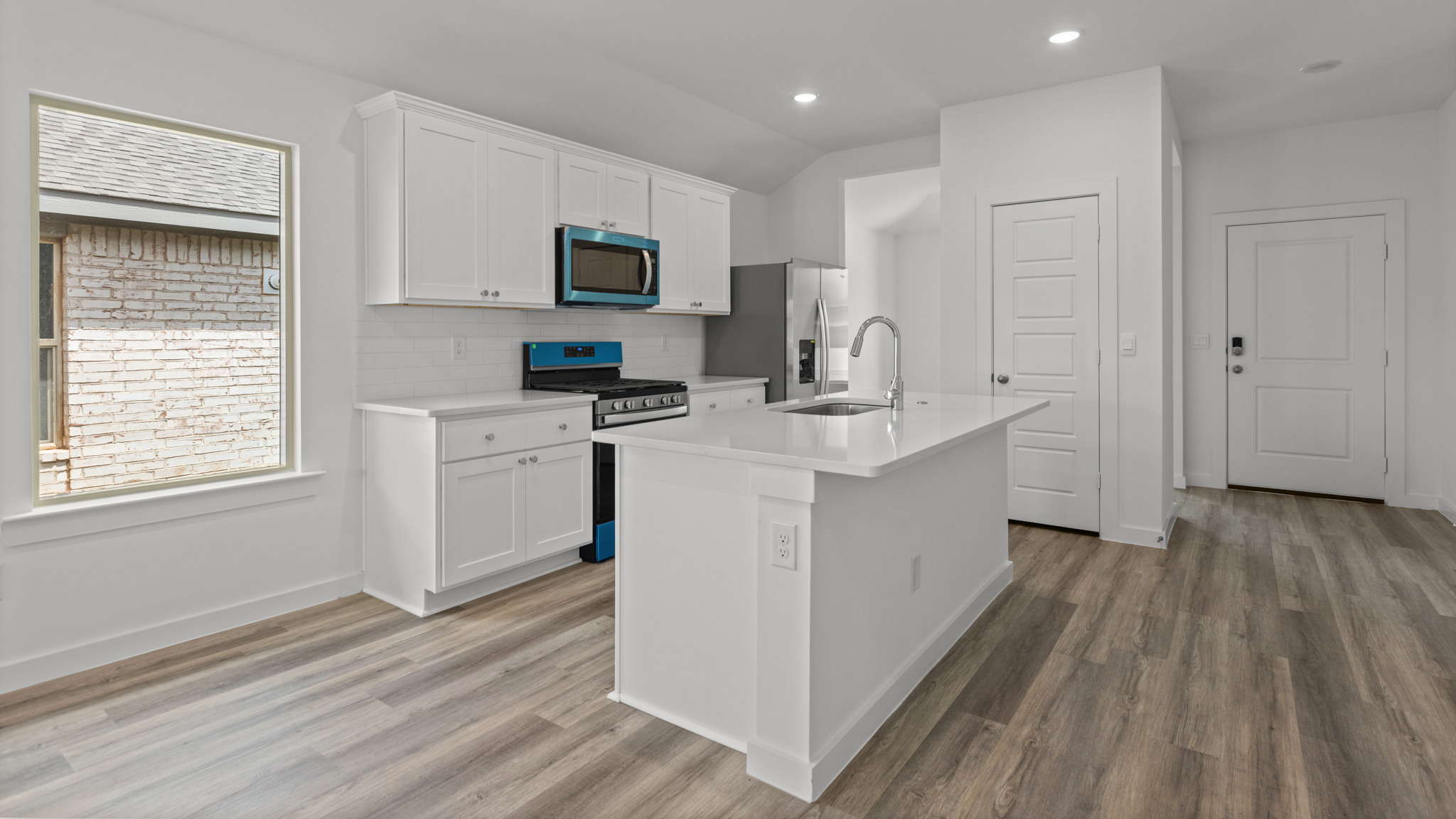 kitchen with spacious island, quartz counters and stainless-steel appliances
