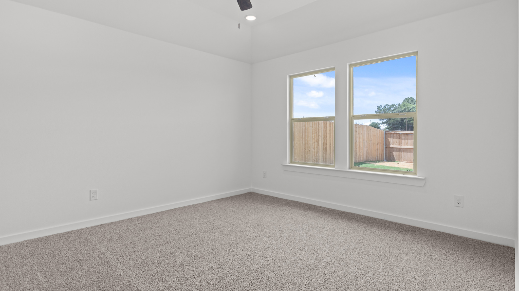 primary bedroom with plush carpet and windows overlooking the backyard
