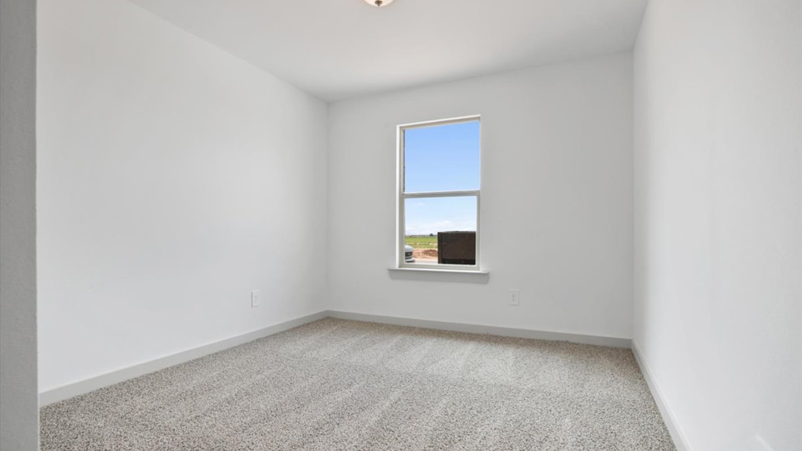 Guest bedroom 1 with plush carpet and side window