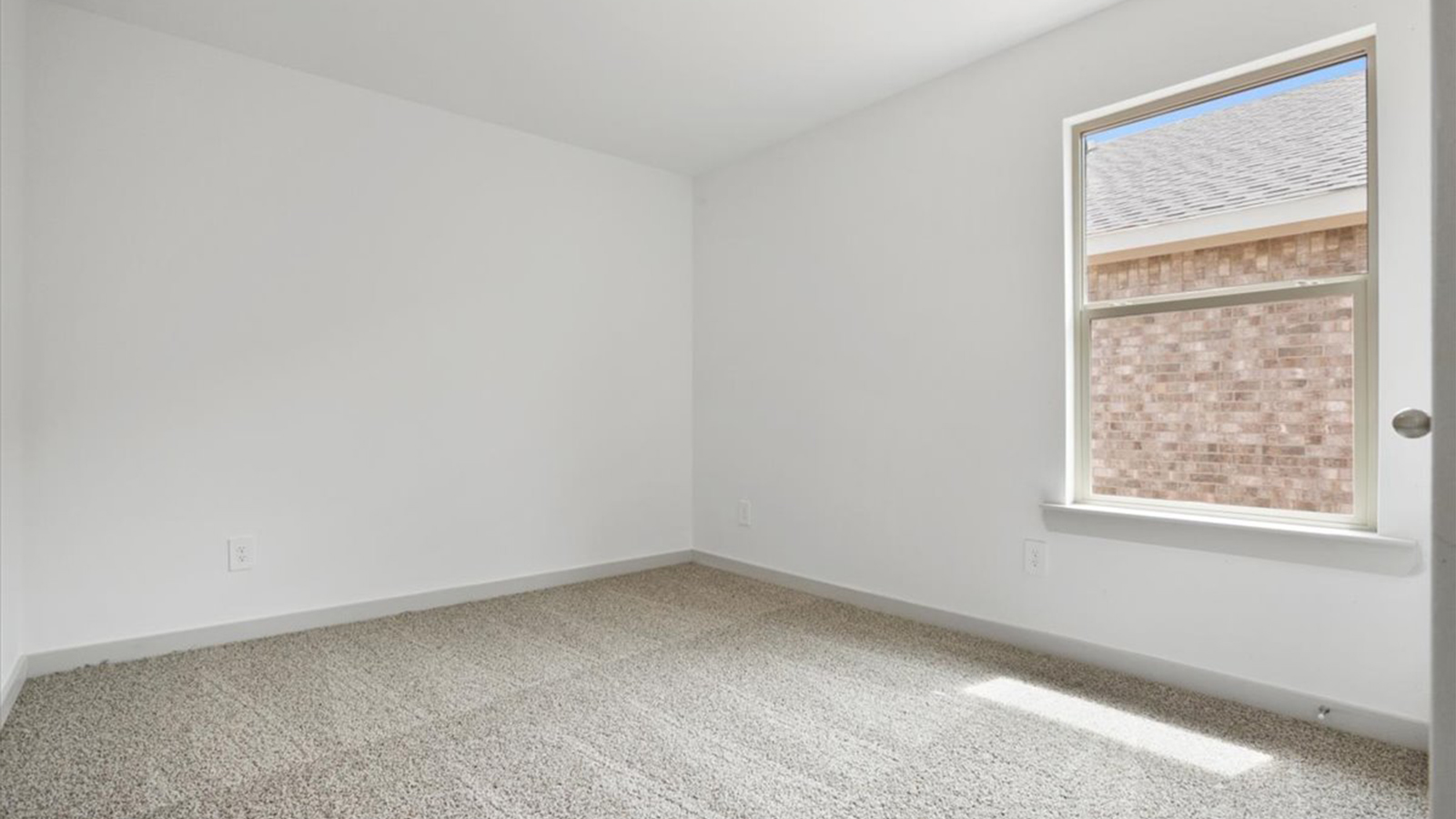 Guest bedroom 2 with plush carpet and side window