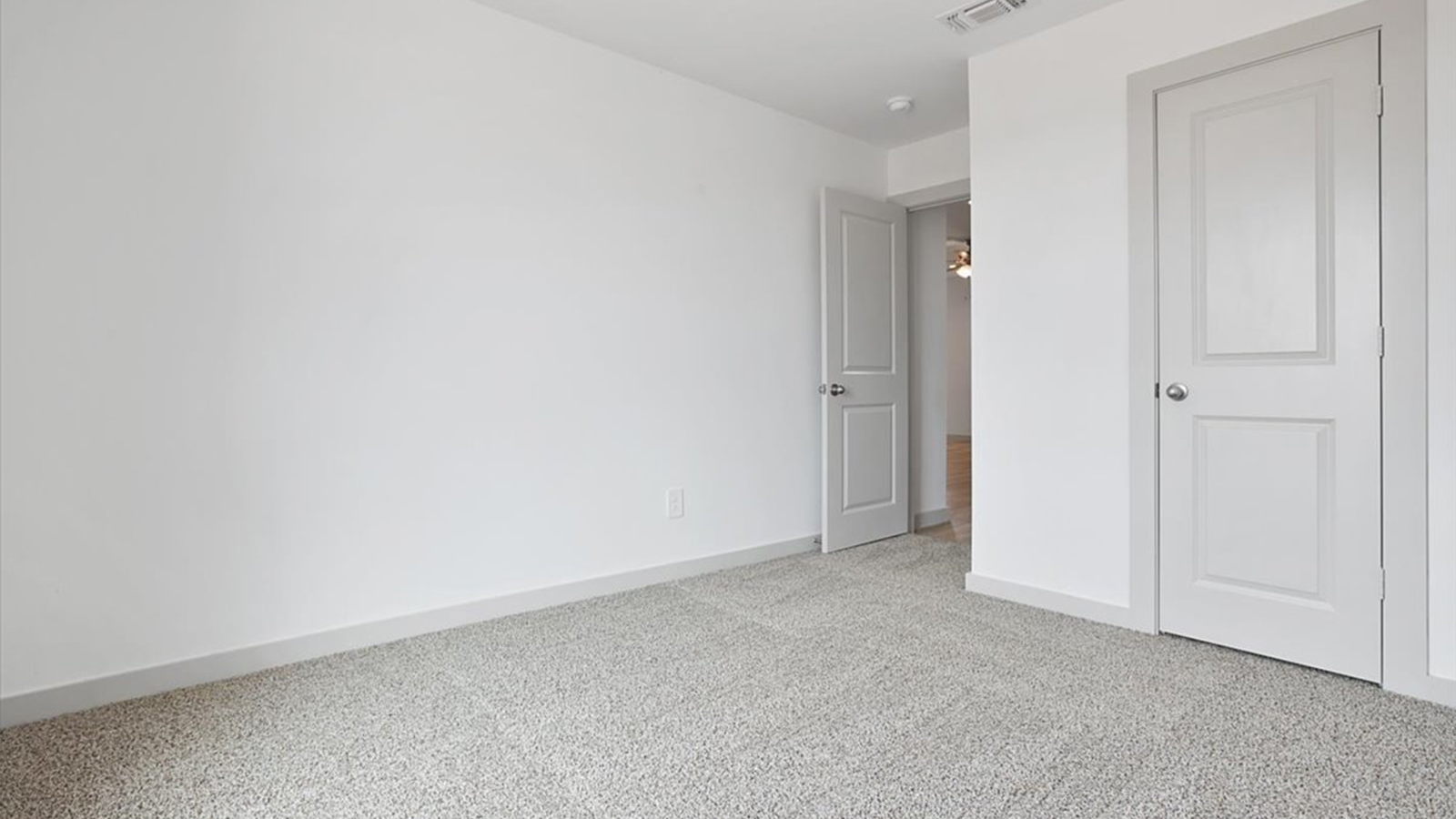 Guest bedroom  with plush carpet floors and spacious closet