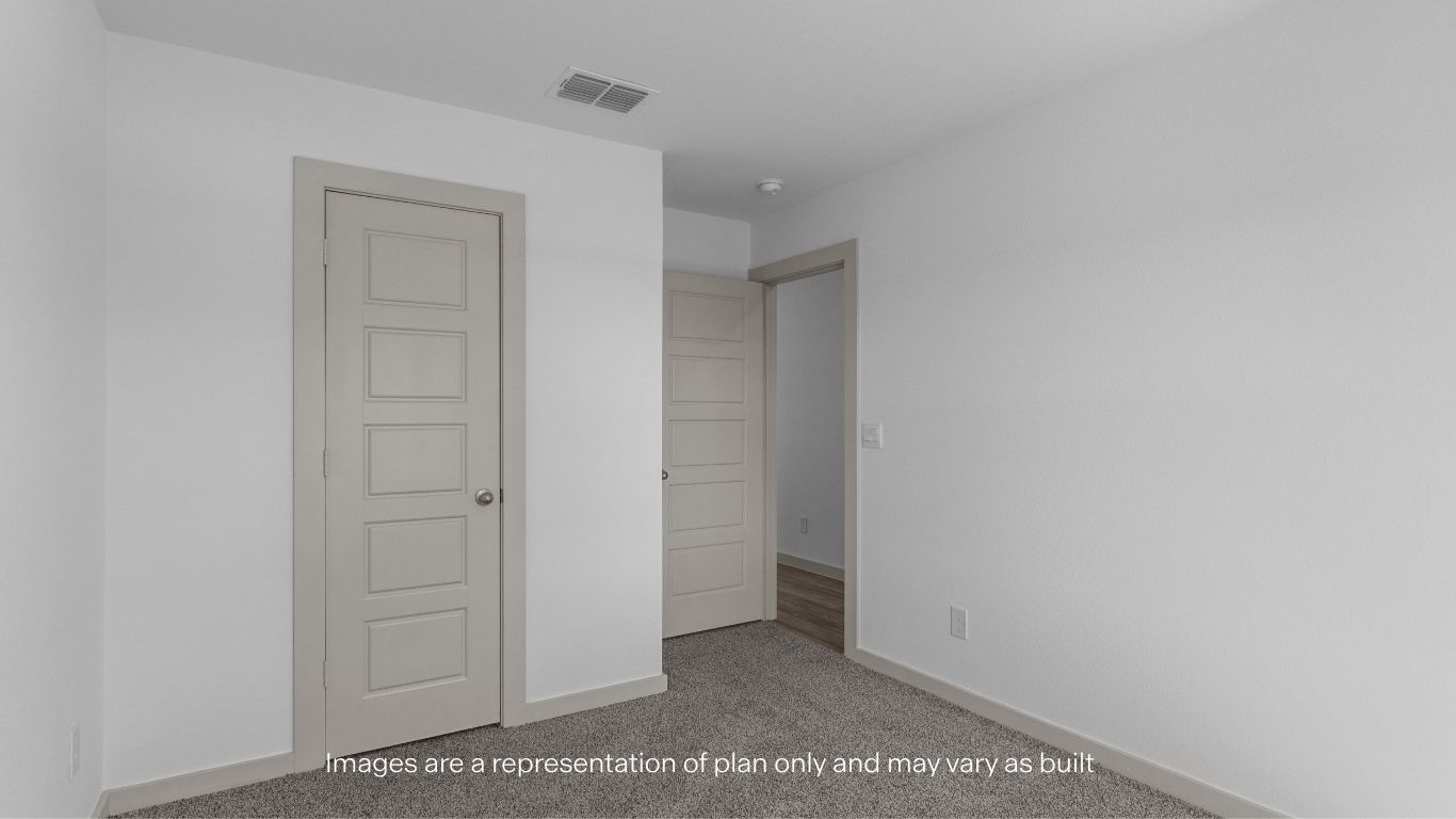 Guest bedroom with plush carpet floors and spacious closet