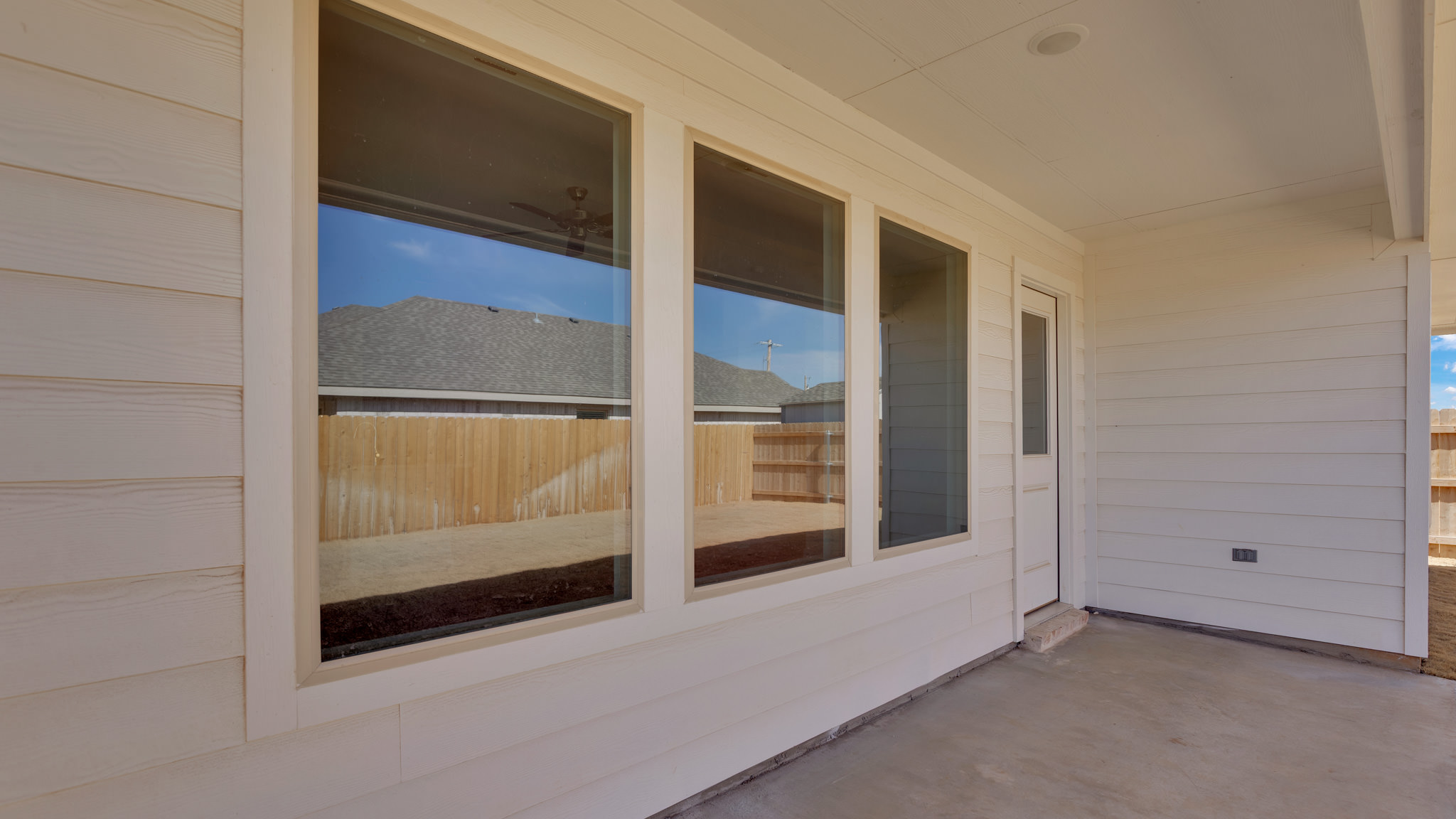 Covered back patio area overlooking spacious backyard